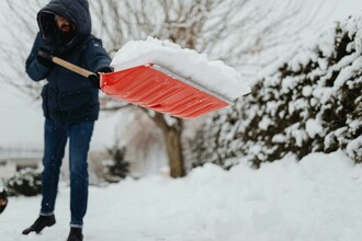 Snow cleared away from a home’s foundation to prevent water damage during spring thaw.
